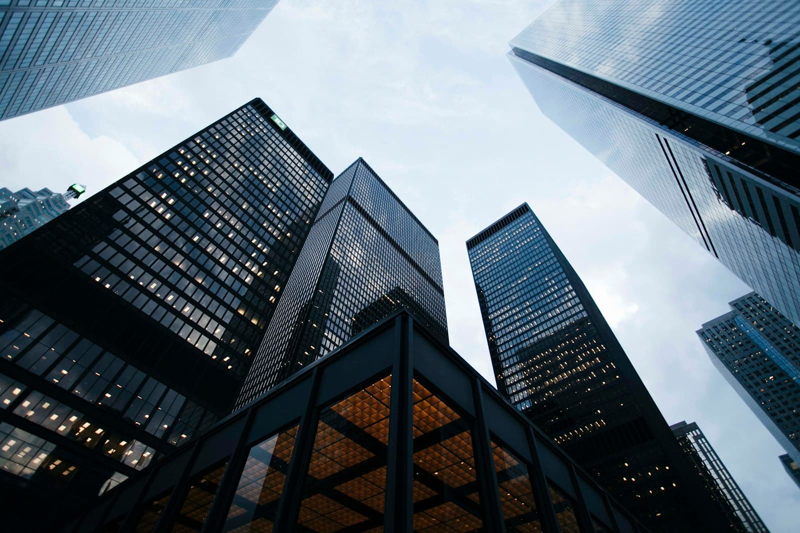 Glass office towers seen from below, converging against the sky